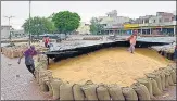  ?? SAMEER SEHGAL/HT PHOTO ?? Workers cover wheat at a market in Amritsar.