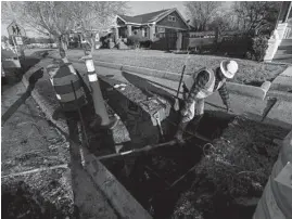  ?? JOSE M. OSORIO/CHICAGO TRIBUNE ?? Nate Dillon, a laborer with J.C. Dillon, Inc., pulls out the old lead service line as polyethyle­ne tubing is installed at a home in Galesburg on March 4.