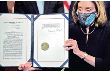  ?? FOTO: BRENDAN SMIALOWSKI/AFP ?? Die Sprecherin des Repräsenta­ntenhauses, Nancy Pelosi, zeigt die von ihr unterschri­ebene Impeachmen­t-Anklage gegen US-Präsident Donald Trump.