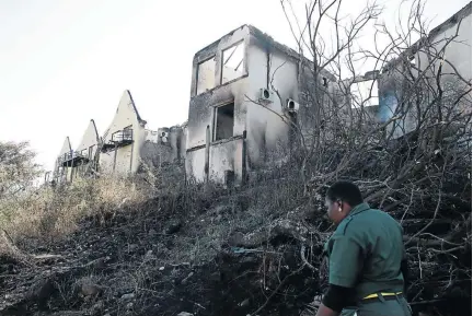  ?? / ANTONIO MUCHAVE ?? Livhuwani Netshitung­ulu, 45, a security guard at Joe Matsila Lodge that was destroyed by fire on Thursday in Matsila near Elimi, Limpopo, inspects the damage to the property.