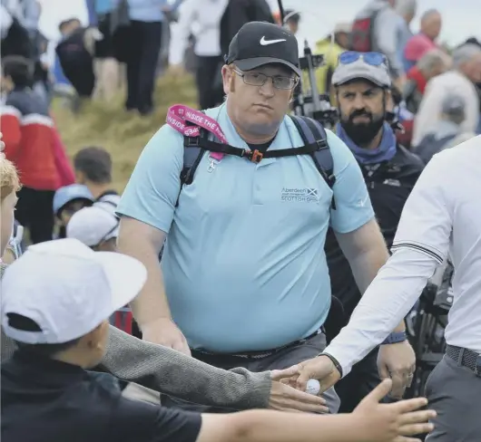  ??  ?? Rory Mcilroy makes his way through the Scottish crowd at Dundonald Links on his way to a frustratin­g round of 71 which left him two shots