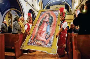  ?? Robin Jerstad / Contributo­r file photo ?? Our Lady of Angels Matachines carry a framed print of Our Lady of Guadalupe down the center aisle for the 2018 Feast of Guadalupe at the Guadalupe Church and Shrine.