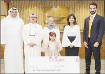  ??  ?? Amnah Bin Nekhi, the winner of KD 250,000 prize with her family and GulfBank team.