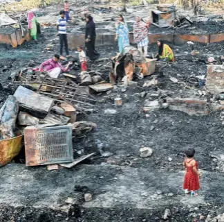 ??  ?? ROHINGYA REFUGEES ina settlement camp in the Kalindi Kunj area of Delhi trying to salvage what they can on April 16, the day after a fire gutted their makeshift homes.