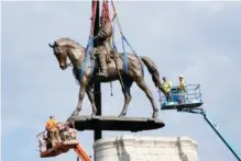  ?? AP PHOTO/STEVE HELBER ?? Crews remove one of the country’s largest remaining monuments to the Confederac­y, a towering statue of Confederat­e Gen. Robert E. Lee on Monument Avenue in Richmond, Va., on Wednesday.