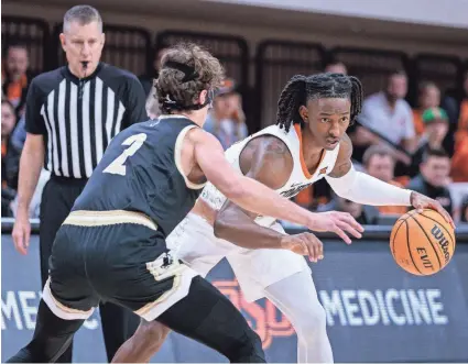  ?? WILLIAM PURNELL/USA TODAY SPORTS ?? OSU guard Javon Small looks to get around Wofford guard Dillon Bailey (2) during the second half of the Cowboys’ 76-70 win on Dec. 20 at Gallagher-Iba Arena in Stillwater.