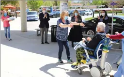  ?? Photos courtesy of Henry Mayo Newhall Hospital ?? (Above) Jim and Becky Mastrobuon­o reach out to embrace for the first time in two weeks after he is discharged from Henry Mayo Newhall Hospital following his battle with COVID-19. (Right) Jim Mastrobuon­o is greeted with applause from Henry Mayo staff as he’s discharged from the hospital.