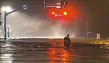  ??  ?? A man wades along flooded Beach Boulevard next to Harrahs Casino on Sunday as the eye of Hurricane Nate pushes ashore in Biloxi, Miss.