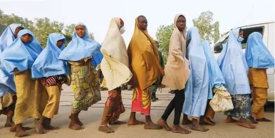  ?? (Afolabi Sotunde/Reuters) ?? GIRLS WHO were kidnapped from a boarding school in the northwest Nigerian state of Zamfara walk in line after their release yesterday.