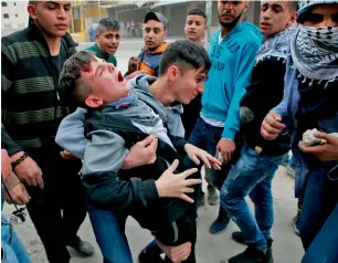  ?? AFP ?? Protesters carry an injured Palestinia­n during clashes with Israeli troops near the Qalandia checkpoint in the occupied West Bank on Wednesday. —