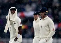  ?? GETTY IMAGES ?? Jofra Archer, left, is well wrapped up as he leaves the field at a chilly Old Trafford.