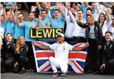  ?? FOTO: PA WIRE/DPA ?? Der alte und neue Weltmeiste­r Lewis Hamilton (vorne) feiert mit seinem Mercedes-Team seinen erneuten Titelgewin­n.