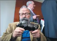  ?? CRAIG RUTTLE / ASSOCIATED PRESS ?? Sculptor Arturo Di Modica holds a model of his “Charging Bull” statue during a news conference on Wednesday.