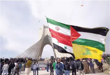  ??  ?? FLAGS FLY in Iran, including Hezbollah and the Syrian flag.