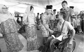  ??  ?? Fadillah chatting with a guest in a wheelchair while Ruziah (second left) looks on. — Photos by Muhammad Rais Sanusi