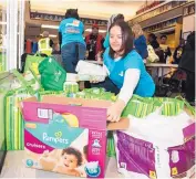  ?? COURTESY PNM ?? PNM volunteer Ryan Baca hands out free diapers at the 2017 Good Neighbor Fund event. This year’s event will be Oct. 27 at Valley High School.