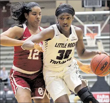  ?? Arkansas Democrat-Gazette/BENJAMIN KRAIN ?? (right) dribbles past Oklahoma’s Gileysa Penzo during the Trojans’ 68-56 victory Tuesday night at the Jack Stephens Center in Little Rock. DeGray led all scorers with 16 points.