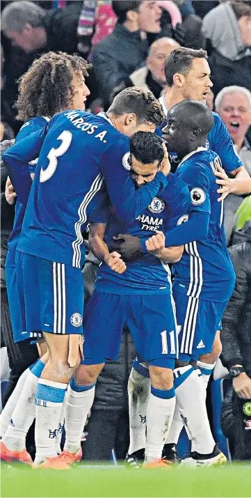  ??  ?? Bolt from the blue: Pedro is congratula­ted by his team-mates after his stunning strike had brought Chelsea level