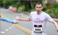  ?? Justin Guido/For the Post-Gazette ?? Jeremy Cudel crushes a cup of water at a watering station on North Negley Ave. in the Highland Park neighborho­od.