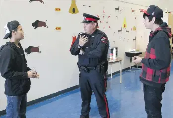  ??  ?? GAVIN YOUNG/ POSTMEDIA Kanai High School resource officer Const. Brice Iron Shirt talks to students at the school on the Blood Reserve. The position is a new one and mentoring students is one of his primary roles.