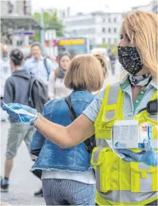  ?? FOTO: GEORGIOS KEFALAS/DPA ?? Eidgenössi­sche Verkehrsbe­triebe lassen von ihren Mitarbeite­rn Schutzmask­en verteilen.