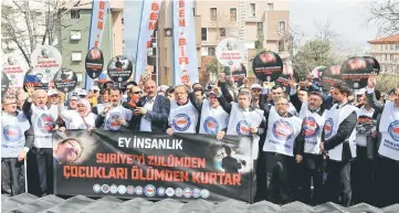  ?? — AFP photo ?? People stand in front of symbolic coffins with pictures of Syrian victims and inscriptio­ns which translates as ‘killer Assad’ and ‘killer Putin’ during a protest against Russia for its alleged role in a chemical attack in the Syrian province of Idlib...