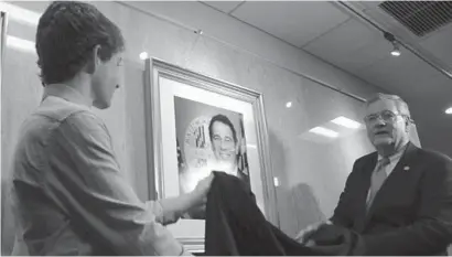  ?? PAMELA WOOD/BALTIMORE SU N PHOTOS ?? Dylan Kamenetz and Baltimore County Executive Don Mohler uncover a portrait of Dylan's late father, former County Executive Kevin Kamenetz. Kamenetz died May 10 and his portrait now hangs in the Historic Courthouse in Towson.