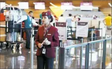  ?? Karim Jaafar/AFP/Getty Images ?? A stewardess waits for passengers at the check-in area Monday in the Hamad Internatio­nal Airport in Doha, Qatar.