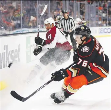  ?? Jae C. Hong Associated Press ?? THE DUCKS’ Josh Mahura (76), making his NHL debut on Sunday night, battles with the Avalanche’s Tyson Jost during the first period. Mahura blocked six shots, took two shots and was a plus-two.