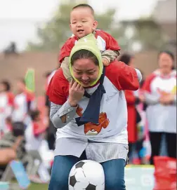  ??  ?? Bonding session: A parent-child game in progress in Chengdu, southwest Sichuan province. Only 18% of qualified couples have responded to the second-child policy so far. — Xinhua
