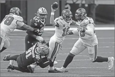  ?? Associated Press ?? Sacked: In this Sunday, Sept. 13, 2020 file photo, Tampa Bay Buccaneers quarterbac­k Tom Brady (12) tries to throw as he is brought down by New Orleans Saints defensive end Trey Hendrickso­n (91) in the first half of an NFL football game in New Orleans. For all the extraordin­ary talent the Saints and Buccaneers have at quarterbac­k, running back and receiver, defensive end Cameron Jordan figures that what happens in the trenches will be the decisive factor in their divisional-round playoff clash.