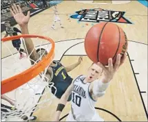  ?? Chris Steppig Associated Press ?? VILLANOVA’S DONTE DIVINCENZO, who scored a careerhigh 31 points, goes past Michigan’s Charles Matthews.