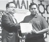  ??  ?? PROGRAM IPC: Madani (kiri) menyampaik­an sijil penyertaan kepada seorang peserta program IPC anjuran Malaysia Automotive Institute (MAI).