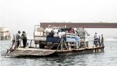  ??  ?? Syrians cross from the city of Raqa to the countrysid­e villages south of the city on ferries due to the destructio­n of the bridge connecting the two areas.