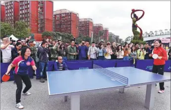  ?? WANG HUAN / FOR CHINA DAILY ?? Ding Ning (right), the Chinese table tennis world champion and Olympic gold medalist, plays with an admirer at a warmup event for the Women’s World Cup of Table Tennis in Chengdu, Sichuan province, on Thursday. The matches run from Friday to Sunday.