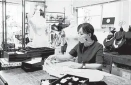  ?? NORIKO HAYASHI/THE NEW YORK TIMES ?? Rieko Kawanishi wears a pearl mask July 17 that she designed at her workshop in Tokyo.