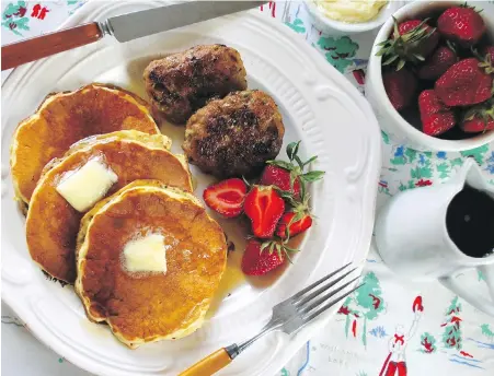  ??  ?? Onward Ranch pancakes are topped with butter and maple syrup and served with local strawberri­es and homemade sausage patties.