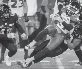  ?? CATHY COWARD, THE HAMILTON SPECTATOR ?? Hamilton’s Alex Langa hauls down Calgary ball carrier Tunde Adeleke during 2nd quarter action at Tim Hortons Field Friday night.