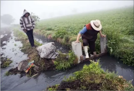  ??  ?? A worker dams off a canal to divert wastewater onto a field where corn will be planted, in Santa Ana Ahuehuepan, north of Tula, Hidalgo state, Mexico.