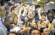  ?? Mark Mulligan / Staff file photo ?? New citizens cheer after taking the oath of allegiance to the U.S. in July, completing their naturaliza­tion.