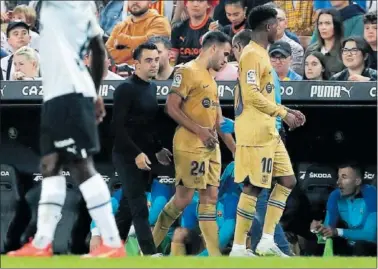  ?? ?? Eric Garcia se marcha lesionado al banquillo en Mestalla mientras Xavi le observa.