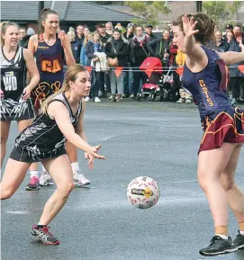  ??  ?? A large crowd gives support during a thrilling A grade contest as Poowong’s Mieke Polman-Short and Warragul Industrial­s’ Katrina Guy work to get their team in front. Photograph­s by Michael Robinson.