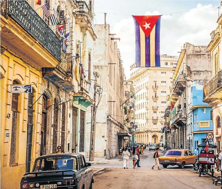  ??  ?? OLD AND OLDER: Above, flags over central Havana; top right are the 1812 ruins of the church of St Anne in Trinidad, founded by early Spanish colonists in the 16th century; bottom right, a classic 1959 Chevy convertibl­e in Trinidad