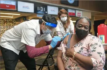  ?? Pittsburgh Post-Gazette ?? Dena Langston, a Pre-K teacher at the Homewood-Brushton YMCA, receives a COVID vaccinatio­n from Muhammad Cheema, a pharmacist with Giant Eagle, in March 2021 at then Heinz Field on the North Shore.