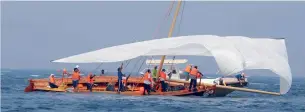  ?? Photos by Leslie Pableo ?? A team checks the sail of their dhow before the beginning of race on Saturday. —