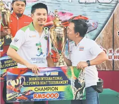  ??  ?? Dawut from Thailand kisses the trophy after winning the Class H category.