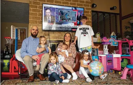  ?? Photos by Annie Mulligan / Contributo­r ?? The Borissov family gathers in their Sugar Land home against a backdrop of a news channel.