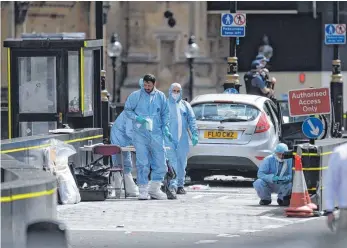  ?? FOTO: DPA ?? Mitarbeite­r der Polizei sichern Spuren nach der Attacke vor dem Westminste­rpalast.