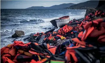  ?? — Getty Images ?? Life jackets and a lifeboat used by refugees litter the north coast of Lesbos near Skala Sikaminias, Greece. Lesbos, the Greek vacation island, faces massive refugee flows.