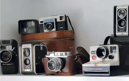  ??  ?? Clockwise from above: Just a few of Papa’s cameras; a closeup of the Kodak Duaflex with top-mounted viewfinder; the Jelco Zoom 77 handcranke­d 8-mm movie camera; Ann as a child, camera in hand, with a smiling Papa seated behind her.